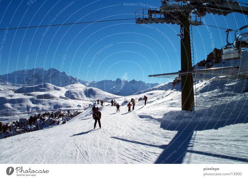 Skigruppe Sport Skifahren Mensch Schnee Berge u. Gebirge Himmel Abfahrt Talfahrt Skipiste Skilift Sesselbahn Mast Rolle Blauer Himmel abwärts Außenaufnahme
