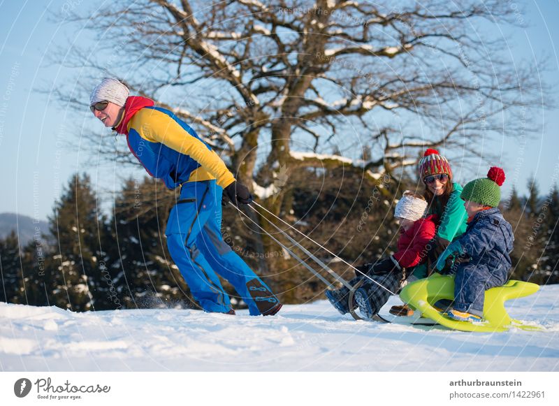 Junges sportliches Paar mit Kindern am Schlitten im Winter bei Sonnenschein Freude Freizeit & Hobby Ferien & Urlaub & Reisen Tourismus Winterurlaub Wintersport