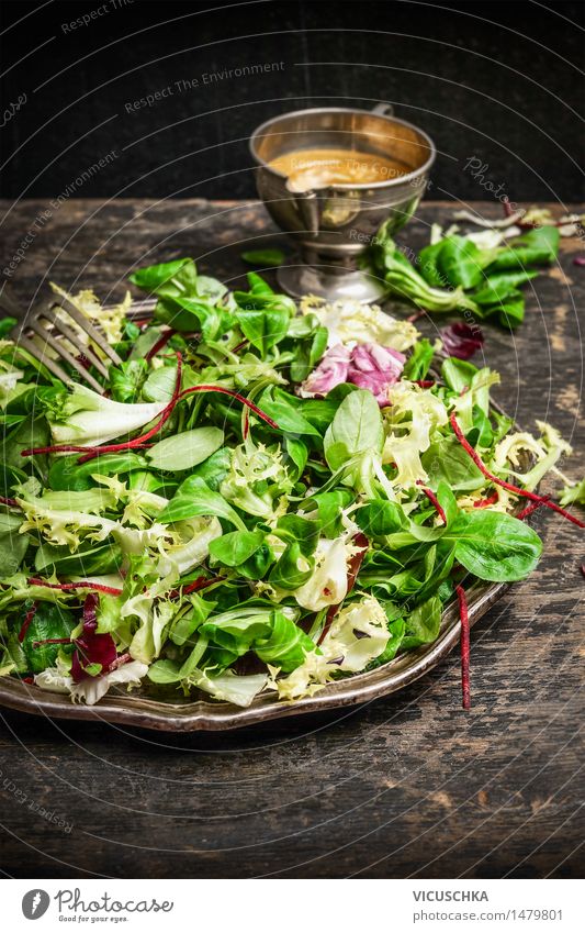 Gesunde grüner Salat mit Dressing auf dunklem Hintergrund Lebensmittel Salatbeilage Ernährung Mittagessen Bioprodukte Vegetarische Ernährung Diät