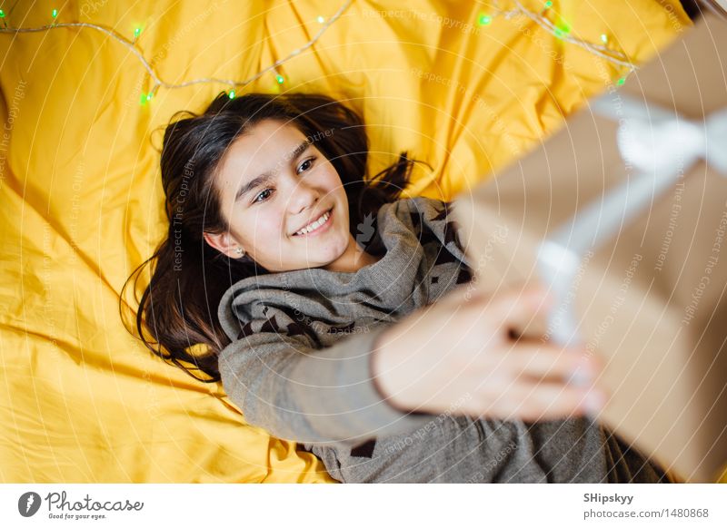 Kleines Mädchen, das ein Geschenk und ein Lächeln hält Traumhaus Wohnzimmer Kinderzimmer Weihnachten & Advent Geburtstag Schwester Freundschaft Jugendliche