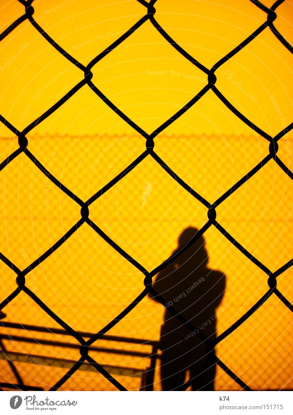 Barriere Hürde Schatten Mensch Mann Zaun Silhouette gefangen Guantanamo privat Grenze gelb Justizvollzugsanstalt Angst Panik