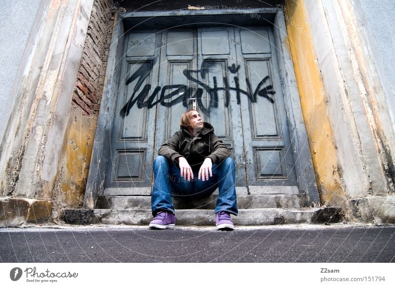 IN THE GHETTO Ghetto Straße sitzen Stil trashig Mann lässig Graffiti Einsamkeit Architektur Tür Tor Jugendliche