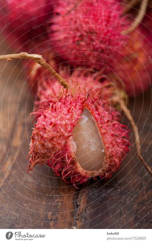 frische tropische Rambutanfrüchte über rustikaler hölzerner Tabelle Frucht Dessert Ernährung exotisch Menschengruppe Natur Pflanze lecker natürlich saftig rot