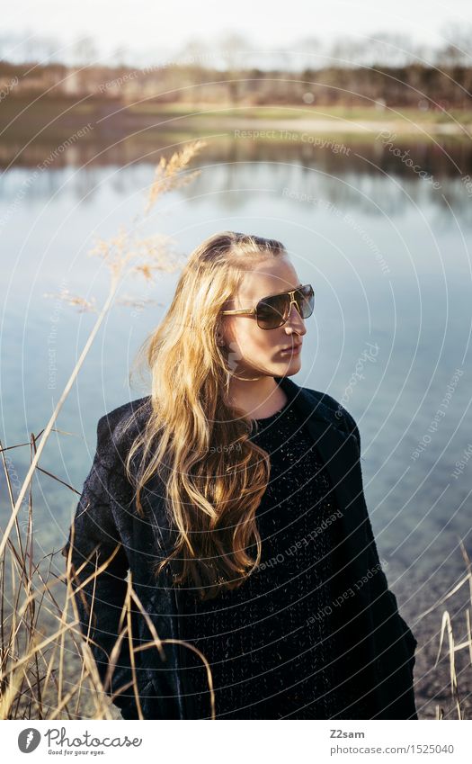 Nochmal Sonne tanken Lifestyle elegant Stil Junge Frau Jugendliche 18-30 Jahre Erwachsene Natur Landschaft Schilfrohr Seeufer Mode Mantel Sonnenbrille blond