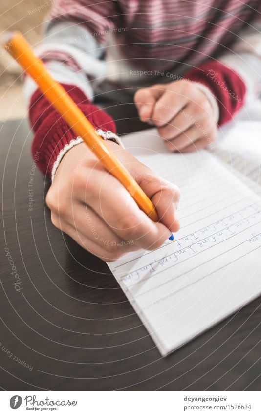Kind schreibt in ein Notizbuch Schule Klassenraum Junge Kindheit Hand Buch Papier Schreibstift schreiben weiß schreibend Bildung Hausaufgabe Notebook Bleistift