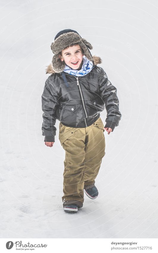 Kind spielt auf dem Schnee Freude Glück Winter Junge Kindheit Natur Park Jacke klein weiß laufen Jahreszeiten kalt Spaziergang weg Rücken eine Frost