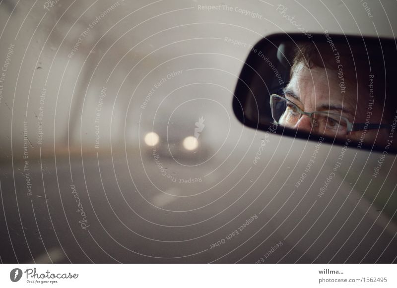Autofahrt im Nebel, Augen mit Brille im Rückspiegel Autofahren Gesicht Konzentration Straße Nebelscheinwerfer Scheinwerfer Vorsicht Wachsamkeit Brillenträger