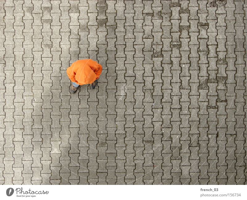 fading shadow Mensch 1 Platz Verkehrswege Bekleidung Pullover Stein Beton Linie stehen warten trist grau Langeweile Farbe orange Kapuze anonym Reihe