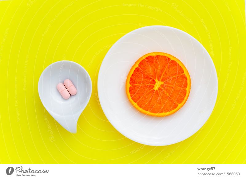 Vitamincocktail II Lebensmittel Frucht Orange Nahrungsergänzungsmittel Ernährung gelb rosa weiß Tablette Orangenscheibe Hintergrund neutral Geschirr