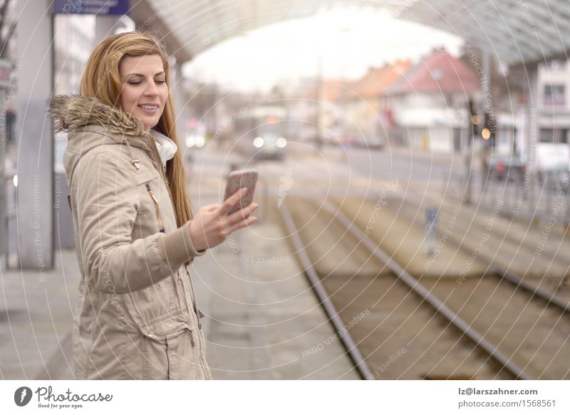 Junge Frau mit Handy an der Bahnstation Glück Ferien & Urlaub & Reisen Winter Telefon Erwachsene 1 Mensch 18-30 Jahre Jugendliche Verkehr Eisenbahn blond