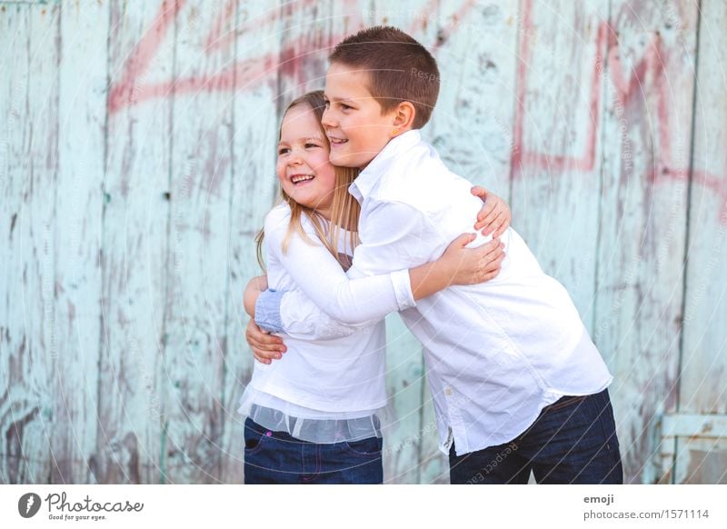 zwei Kinder, ein Junge und ein Mädchen, umarmen sich und lachen, Blick zur Seite Geschwister Kindheit 2 Mensch 8-13 Jahre Fröhlichkeit Zusammensein Glück