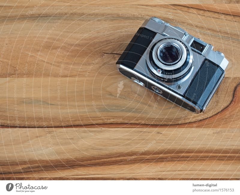 analoge Kleinbildkamera auf braunem Holztisch Fotokamera Technik & Technologie alt retro schwarz silber abbild Aussehen antik Gerät Hintergrundbild Blende