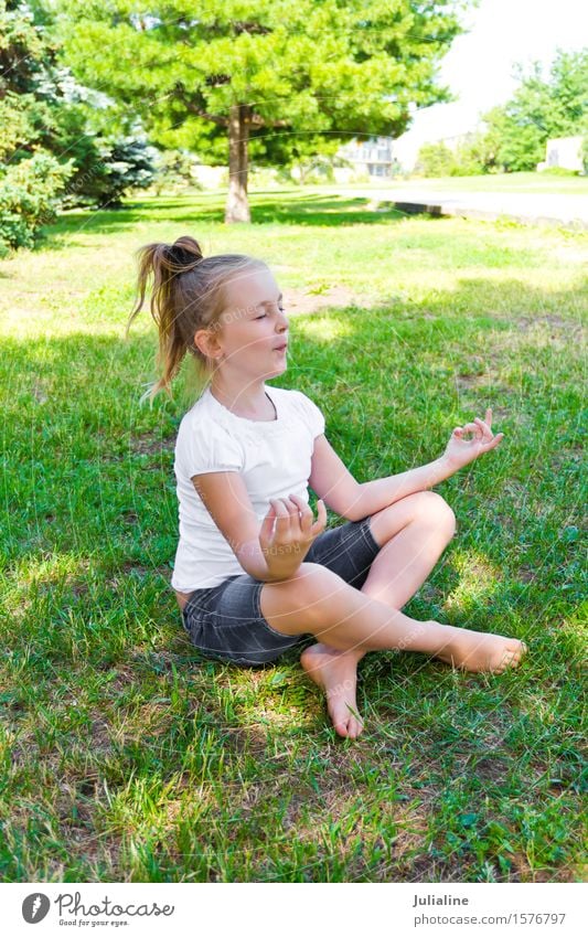 Nettes Mädchen sitzen auf grünem Gras Sommer Yoga Kind Schulkind Kindheit 8-13 Jahre blond blau weiß Lotos Pose Vorschulkind sechs 7 Kaukasier Europäer fünf