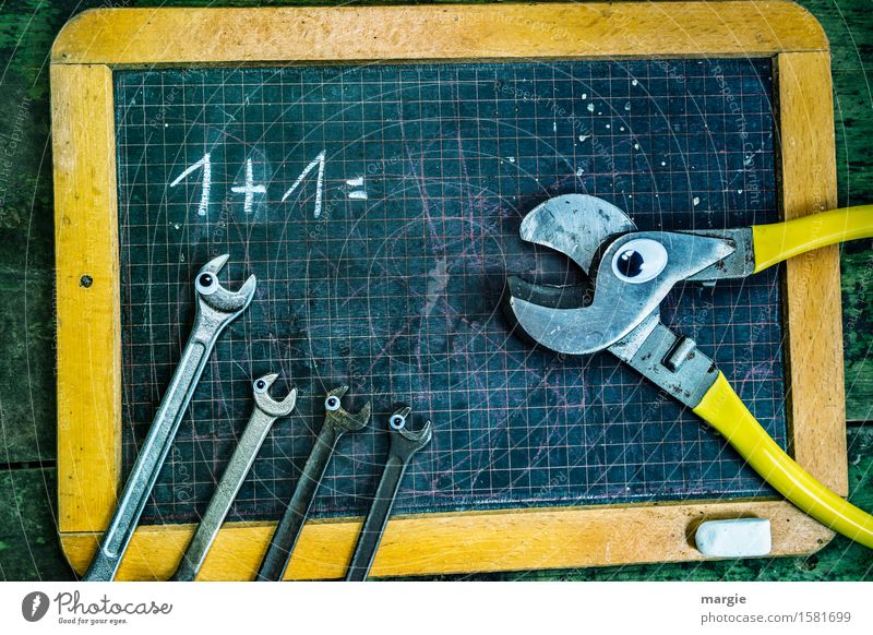1 + 1 = ? Eine Zange und vier Schraubenschlüssel mit Augen auf einer alten Rechentafel Schule Tafel Schulkind Schüler Lehrer Beruf Handwerker Arbeitsplatz