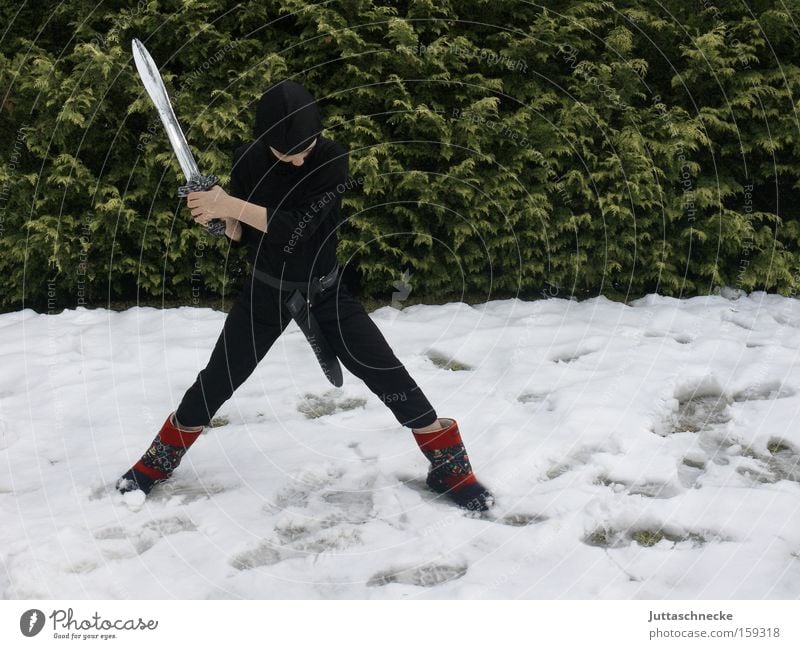 Nieder mit dem Winter Junge Kind Ninja Karnevalskostüm kämpfen Kampfsport Schnee Schwert erobern verkleidet Außenaufnahme Jugendliche