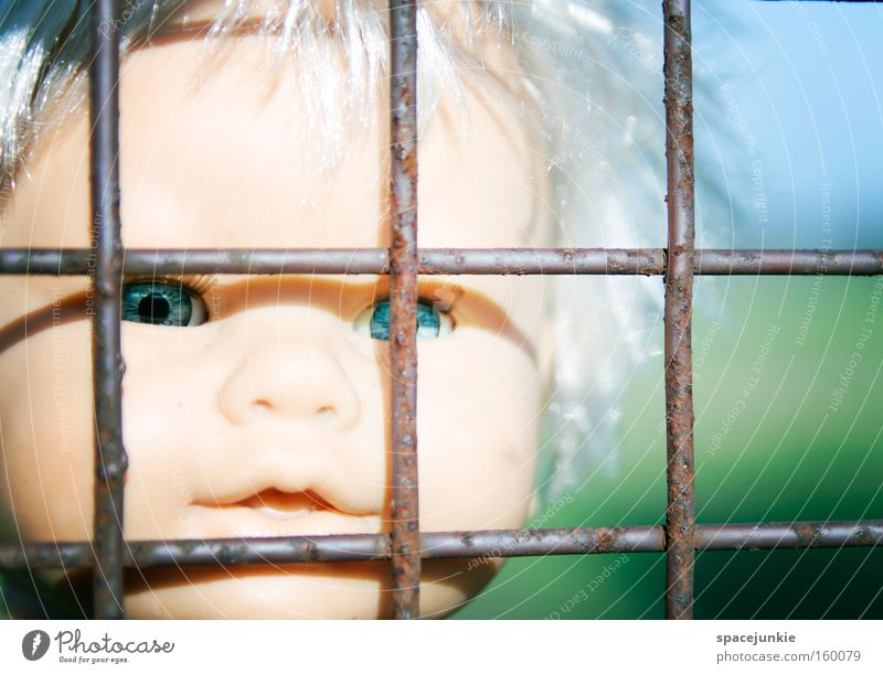 Behind bars Gitter Eisen gefangen Einsamkeit Puppe Spielzeug Kunststoff Kopf Blick Sehnsucht Freiheit Flucht Auge Justizvollzugsanstalt Angst Panik