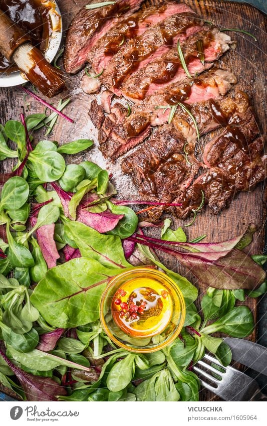 Geschnittenes Steak vom Grill serviert mit grünem Salat Lebensmittel Fleisch Gemüse Salatbeilage Kräuter & Gewürze Öl Ernährung Mittagessen Abendessen Festessen
