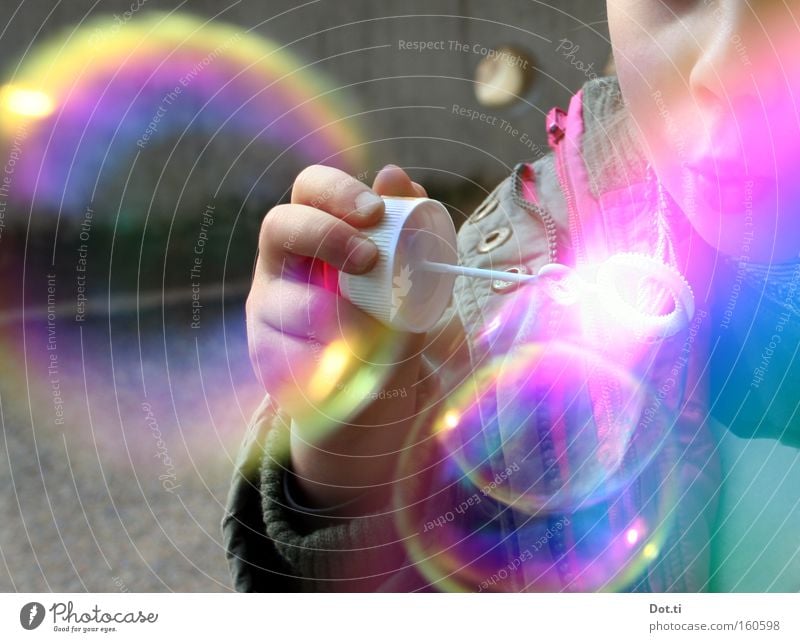 Kind mit bunten Seifenblasen Farbfoto mehrfarbig Außenaufnahme Textfreiraum links Tag Reflexion & Spiegelung Oberkörper Freude Spielen Mensch Kleinkind Mädchen