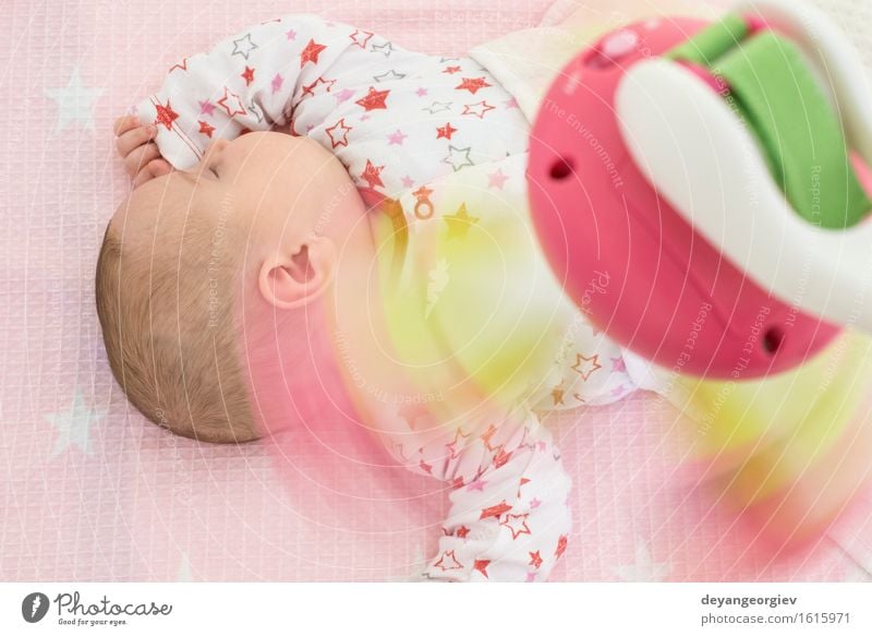 Baby in einem Bett mit Spielwaren herum. Glück Körper Gesicht Sonne Schlafzimmer Kind Mädchen Kindheit Bekleidung Spielzeug schlafen klein neu weich rosa weiß
