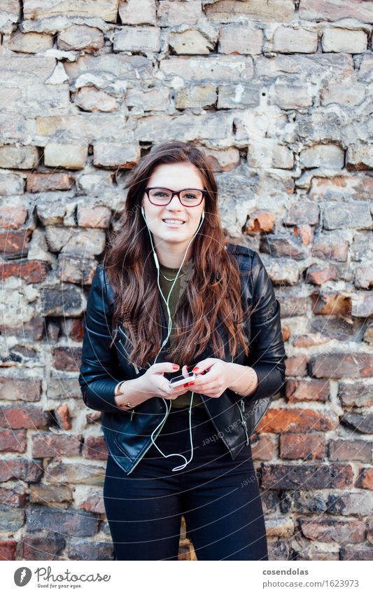 Junge Frau mit Smartphone in der Hand hört Musik Lifestyle Freizeit & Hobby Student feminin Jugendliche 18-30 Jahre Erwachsene brünett langhaarig hören