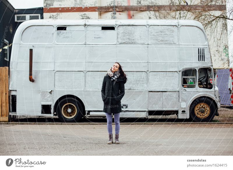 Junge Frau steht vor einem Bus feminin Jugendliche Erwachsene 18-30 Jahre stehen kalt old-school retro Jacke Mantel brünett Winter Porträt Farbfoto Tag
