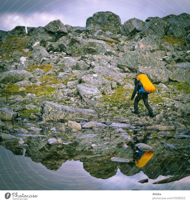 Irrwege XII Abenteuer Berge u. Gebirge wandern 1 Mensch Natur schlechtes Wetter Felsen Seeufer grau orange Kraft Willensstärke Leidenschaft Risiko Irritation