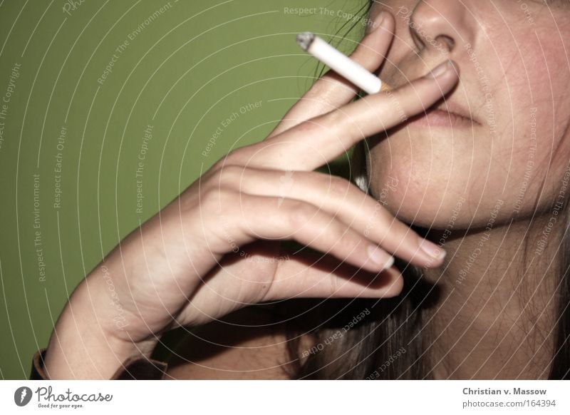 Junge Frau mit Zigarette vor grünem Hintergrund Farbfoto Gedeckte Farben Innenaufnahme Nahaufnahme Textfreiraum links Textfreiraum oben Hintergrund neutral