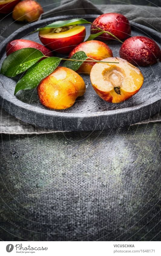 Frische Pfirsiche mit grünen Blättern auf Steinplatte Lebensmittel Frucht Dessert Ernährung Bioprodukte Vegetarische Ernährung Diät Saft Teller Stil Design