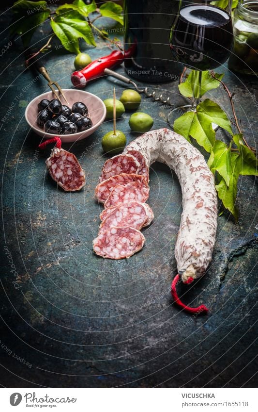 Geschnittene Salami mit Antipasti , Rotwein und Weinblätter Lebensmittel Wurstwaren Gemüse Ernährung Mittagessen Büffet Brunch Festessen Italienische Küche