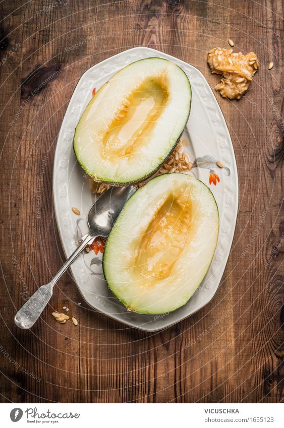 Zwei Hälften der Honig Melone mit Samen und Löffel Lebensmittel Frucht Dessert Ernährung Bioprodukte Vegetarische Ernährung Saft Teller Stil Gesunde Ernährung