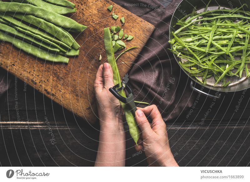 Weibliche Hände schneiden Bohnen mit Gemüseschäler . Lebensmittel Ernährung Mittagessen Abendessen Bioprodukte Vegetarische Ernährung Diät Topf Messer Stil