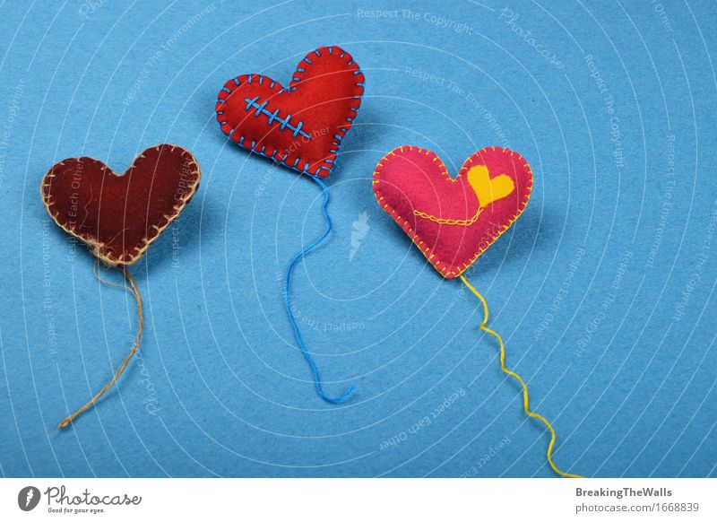Drei Spielzeugherzen mit den Threads, rot, rosa und braun auf Blau Freizeit & Hobby Handarbeit Kunst Herz Liebe blau gelb Zusammensein Romantik Kreativität Filz