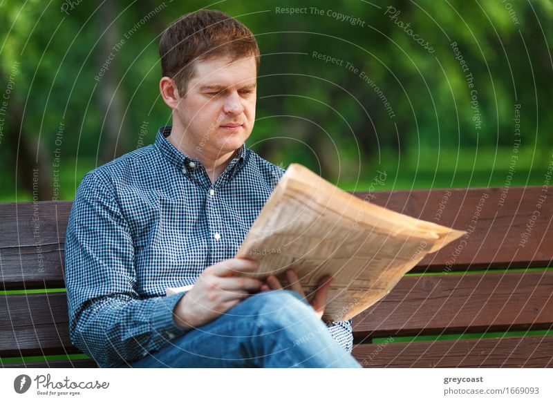 Mann liest Zeitung auf Bank im Park Lifestyle Glück Erholung lesen Garten Business Mensch Junger Mann Jugendliche Erwachsene 1 18-30 Jahre Magazin Papier