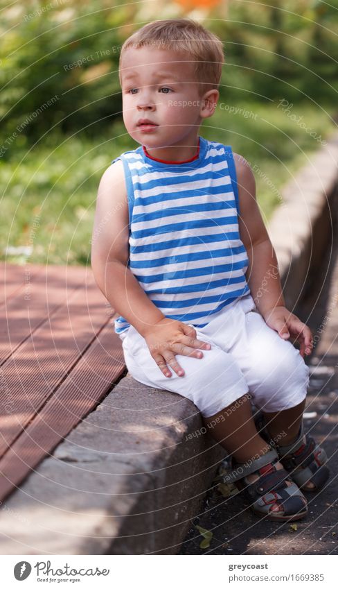 Porträt eines dreijährigen Jungen, der auf dem Bordstein sitzt und nach links schaut Lifestyle Gesicht Sommer Kind Mensch Baby Kleinkind Kindheit 1 1-3 Jahre