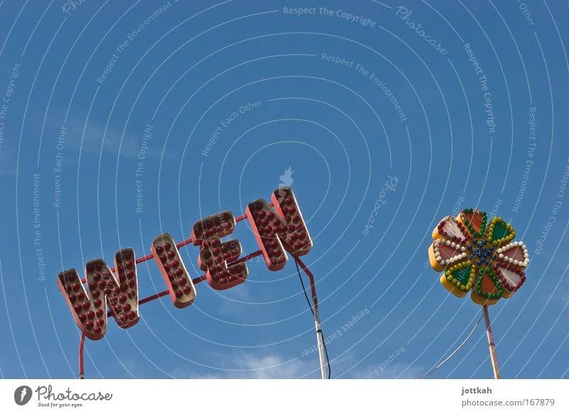 Schriftzug "Wien" und eine Blüte bestehend aus bunten Glühbirnen Hauptstadt Freizeit & Hobby Tourismus Prater Jahrmarkt Typographie Leuchtreklame Himmel
