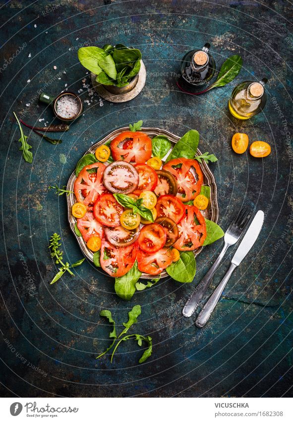 Tomatensalat mit bunten Tomaten , Besteck und Dressing Lebensmittel Gemüse Salat Salatbeilage Kräuter & Gewürze Öl Ernährung Festessen Bioprodukte