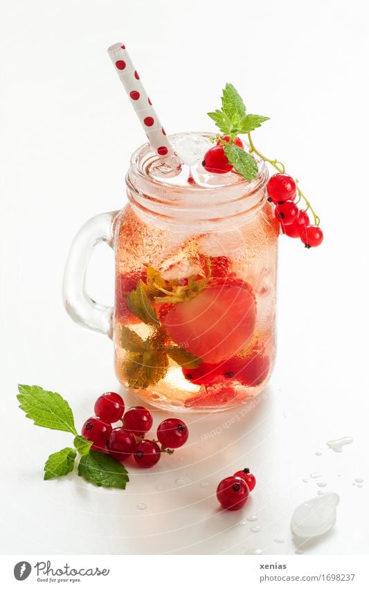 Ein Glas kühles leckeres Erfrischungsgetränk mit Erdbeere und Johannisbeere auf weißem Hintergrund Getränk Johannisbeeren Erdbeeren Limonade Frucht Trinkwasser