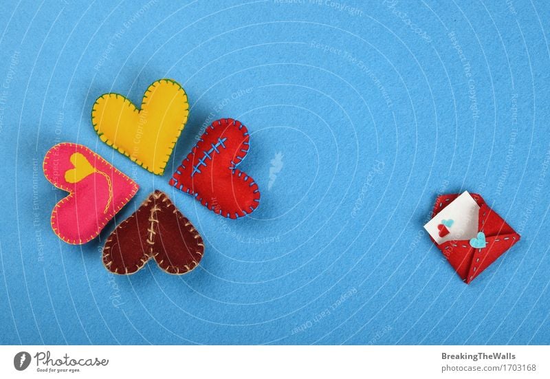 Vier bunte handgemachte genähte Spielzeugherzen auf blauem Filz Lifestyle Design Freizeit & Hobby Basteln Handarbeit Valentinstag Kunst Kunstwerk Herz Liebe