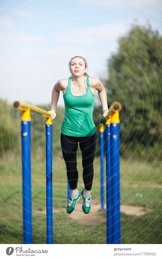 Attraktive fitte junge Frau Turnerin übt im Freien auf parallelen Barren während eines Trainings Workout Sport Fitness Sport-Training Junge Frau Jugendliche