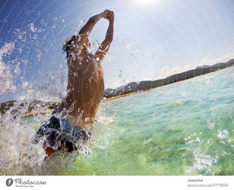 Der Junge springend in Wasser, Spaß spielend und habend Freude Glück Spielen Ferien & Urlaub & Reisen Sommer Sonne Strand Meer Sport Kind Mensch Mann Erwachsene