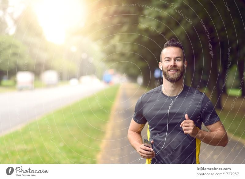 Mann joggt entlang eines von Bäumen gesäumten Bürgersteigs Lifestyle Glück Körper Gesicht Musik Sport Joggen maskulin Erwachsene 1 Mensch 18-30 Jahre