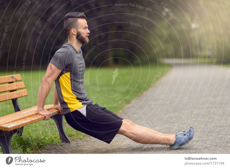 Junger Mann, der in einem Park trainiert Lifestyle Körper Sport Erwachsene 1 Mensch Natur Vollbart Holz Fitness sportlich modern Aktion Gleichgewicht bärtig