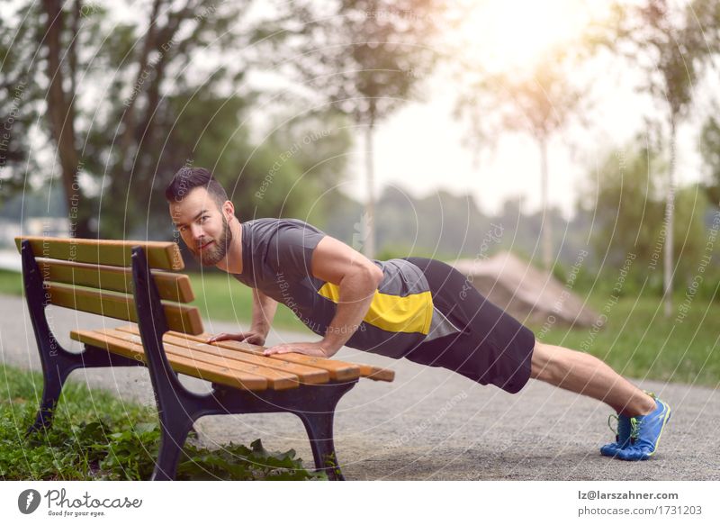 Junger Mann beim Liegestützen auf einer hölzernen Parkbank Lifestyle Körper Gesicht Sport Erwachsene 1 Mensch 18-30 Jahre Jugendliche Vollbart Fitness Aktion