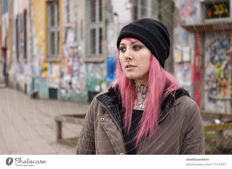 gepiercte und tätowierte Frau vor Graffiti bedecktem Gebäude Lifestyle Arbeitslosigkeit Mensch Junge Frau Jugendliche Erwachsene 1 18-30 Jahre Jugendkultur