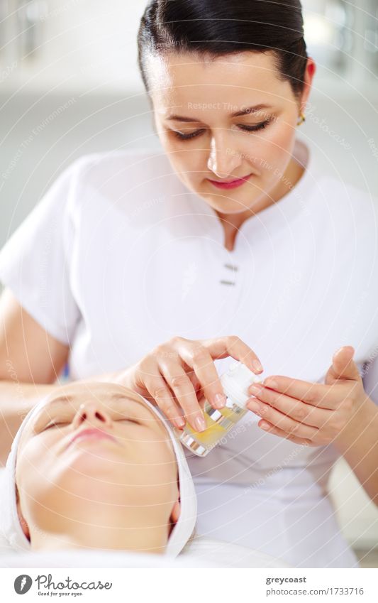 Die Kosmetikerin wird die Gesichtskosmetik während der Behandlung im Schönheitssalon anwenden Haut Gesundheitswesen Spa Arzt Mensch Mädchen Frau Erwachsene
