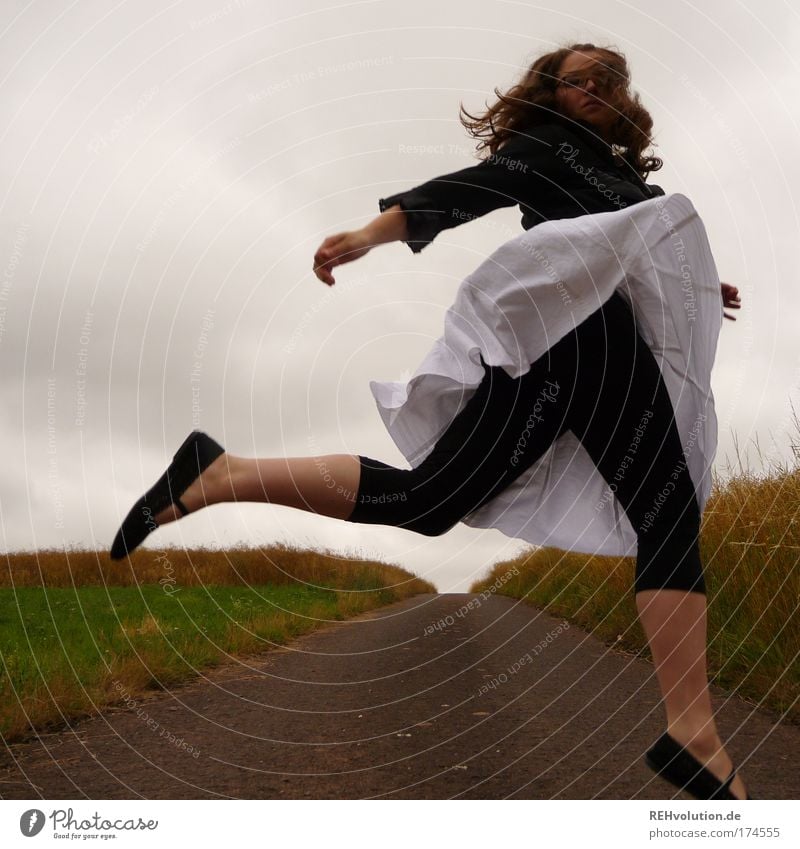 Frau springt auf einer Straße Farbfoto Außenaufnahme Ganzkörperaufnahme Freude Mensch feminin Junge Frau Jugendliche 1 18-30 Jahre Erwachsene Landschaft Wiese