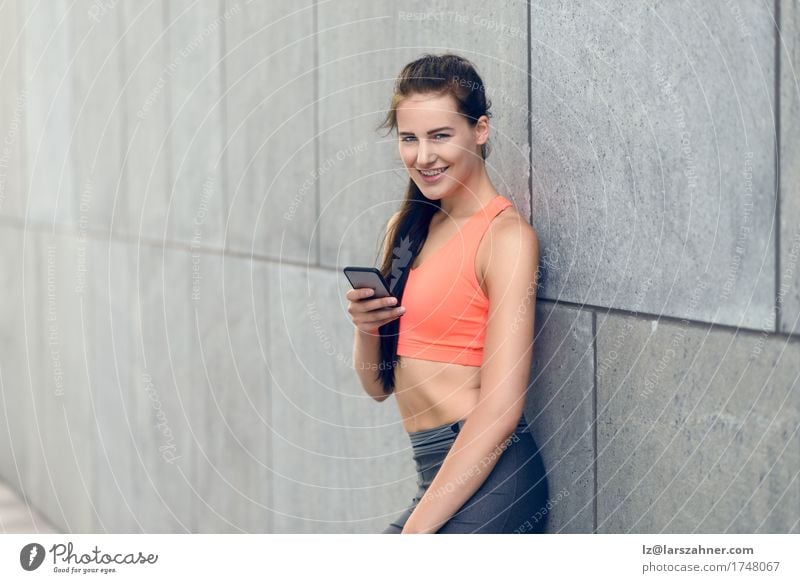Sportliche junge Frau mit ihrem Mobile Gesicht Sommer Telefon PDA Erwachsene 1 Mensch 18-30 Jahre Jugendliche Wärme brünett Fitness Lächeln stehen sportlich