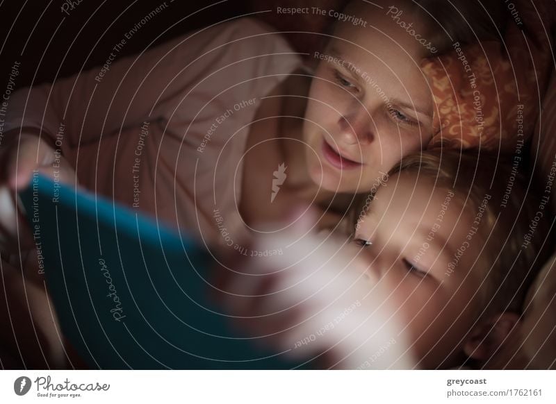 Mutter und kleiner Sohn sehen sich nachts im Bett liegend ein Video an oder spielen auf dem Touchpad Spielen Kind Computer Junge Junge Frau Jugendliche