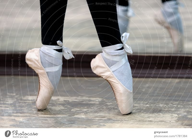 Nahaufnahme von Ballerinas Beinen in weißen Spitzen auf Holzboden in Spitzenposition. elegant Stil schön Tanzen Schule Beruf Mädchen Fuß 1 Mensch Tänzer