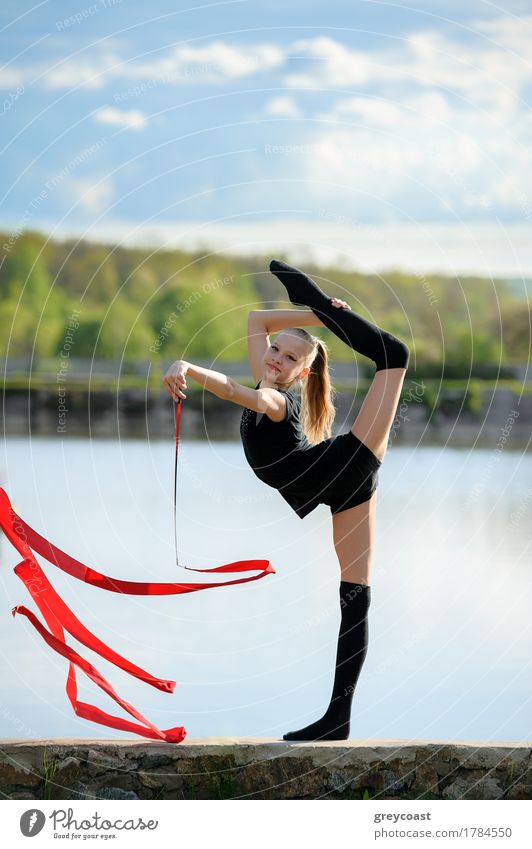 Teenager Rhythmische Sportgymnastin hält Bein in vertikaler Spaltung tun Band Übungen. Körper Sommer Garten Fitness Sport-Training Mensch feminin Mädchen Frau
